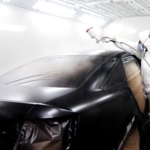 a technician spray painting a car